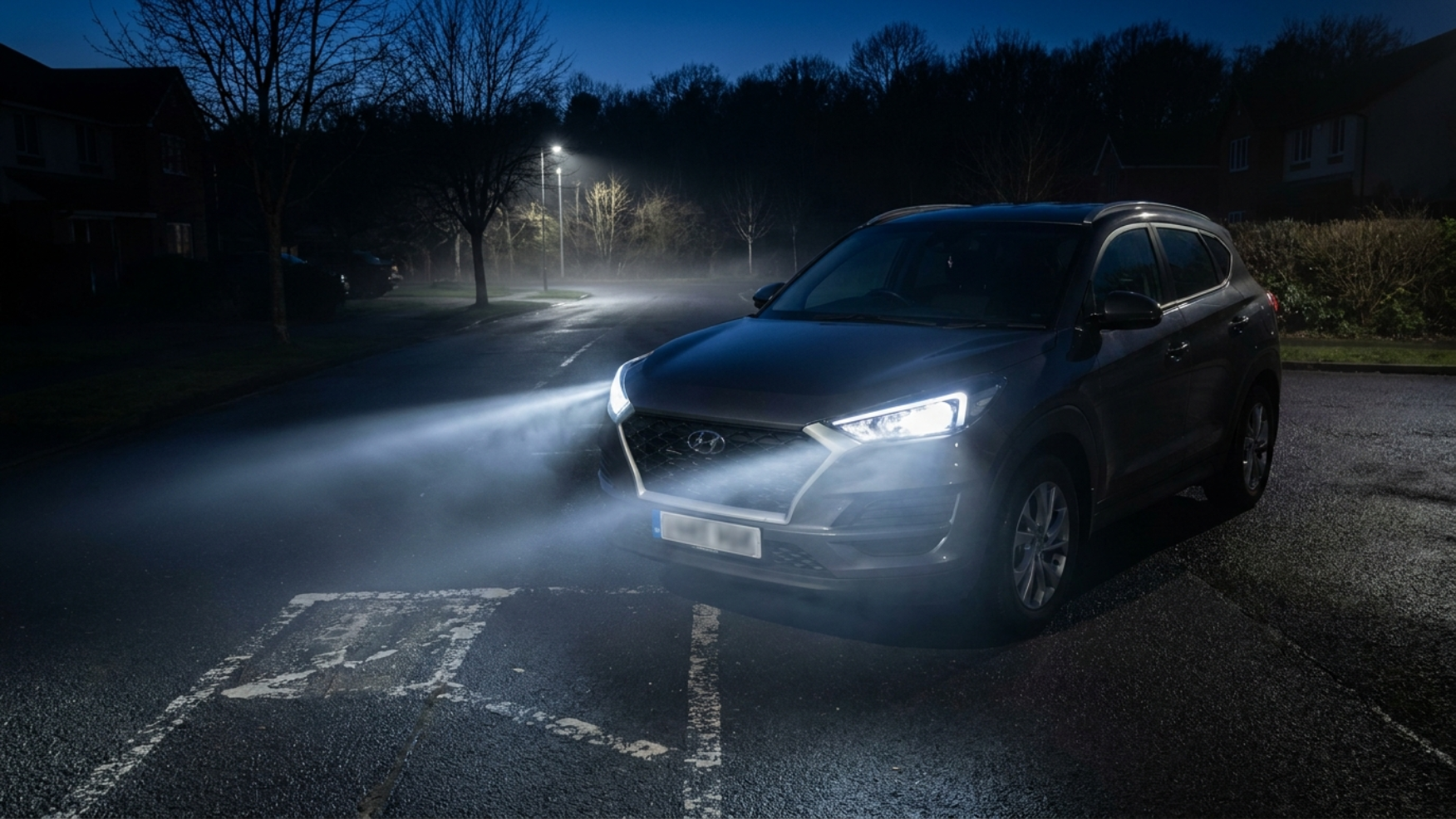 Hyundai Tucson TL ночью со включёнными фарами освещает пустую загородную дорогу