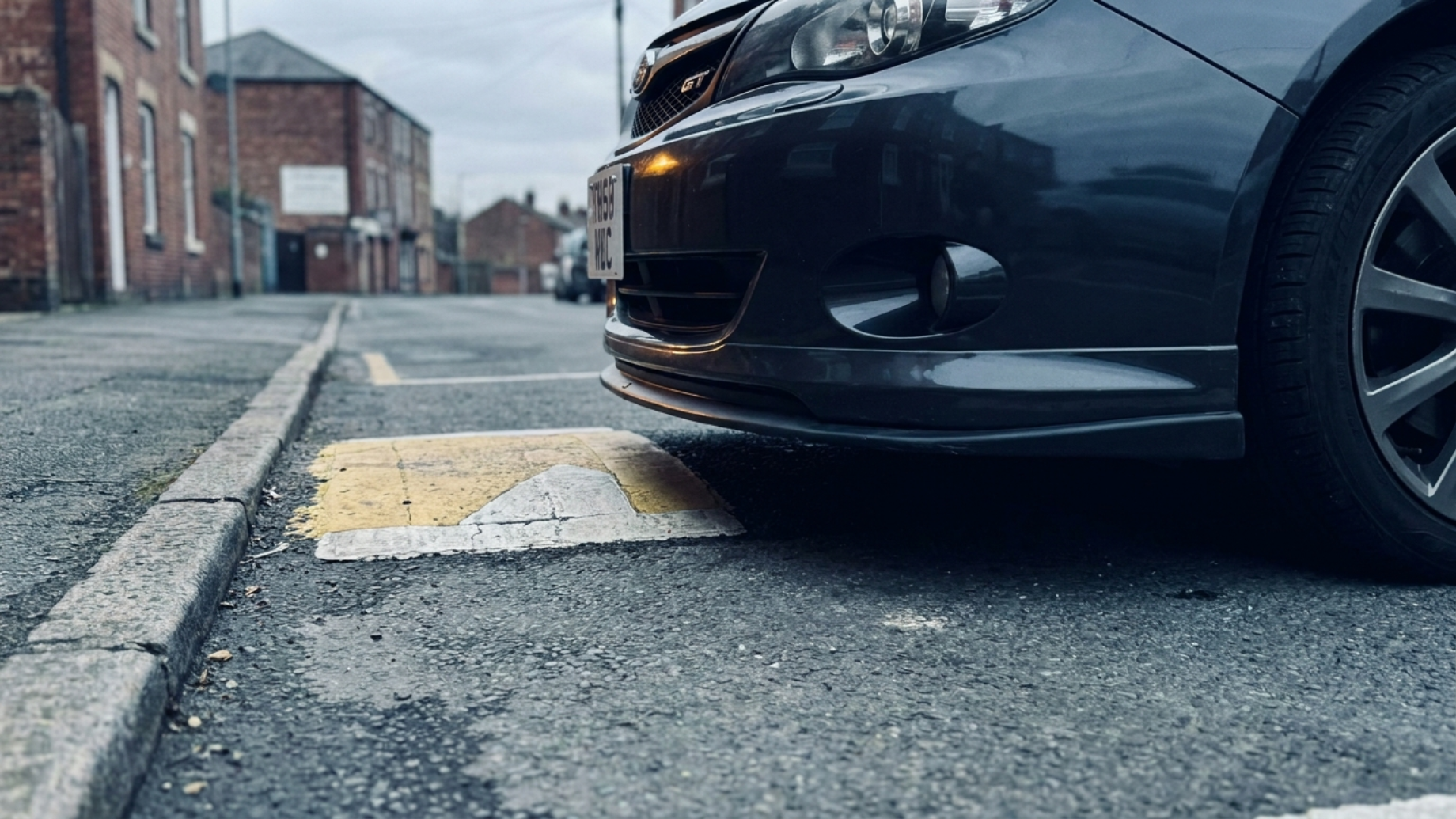 Передний бампер Subaru Impreza GT у лежачего полицейского, виден большой передний свес и низкая посадка