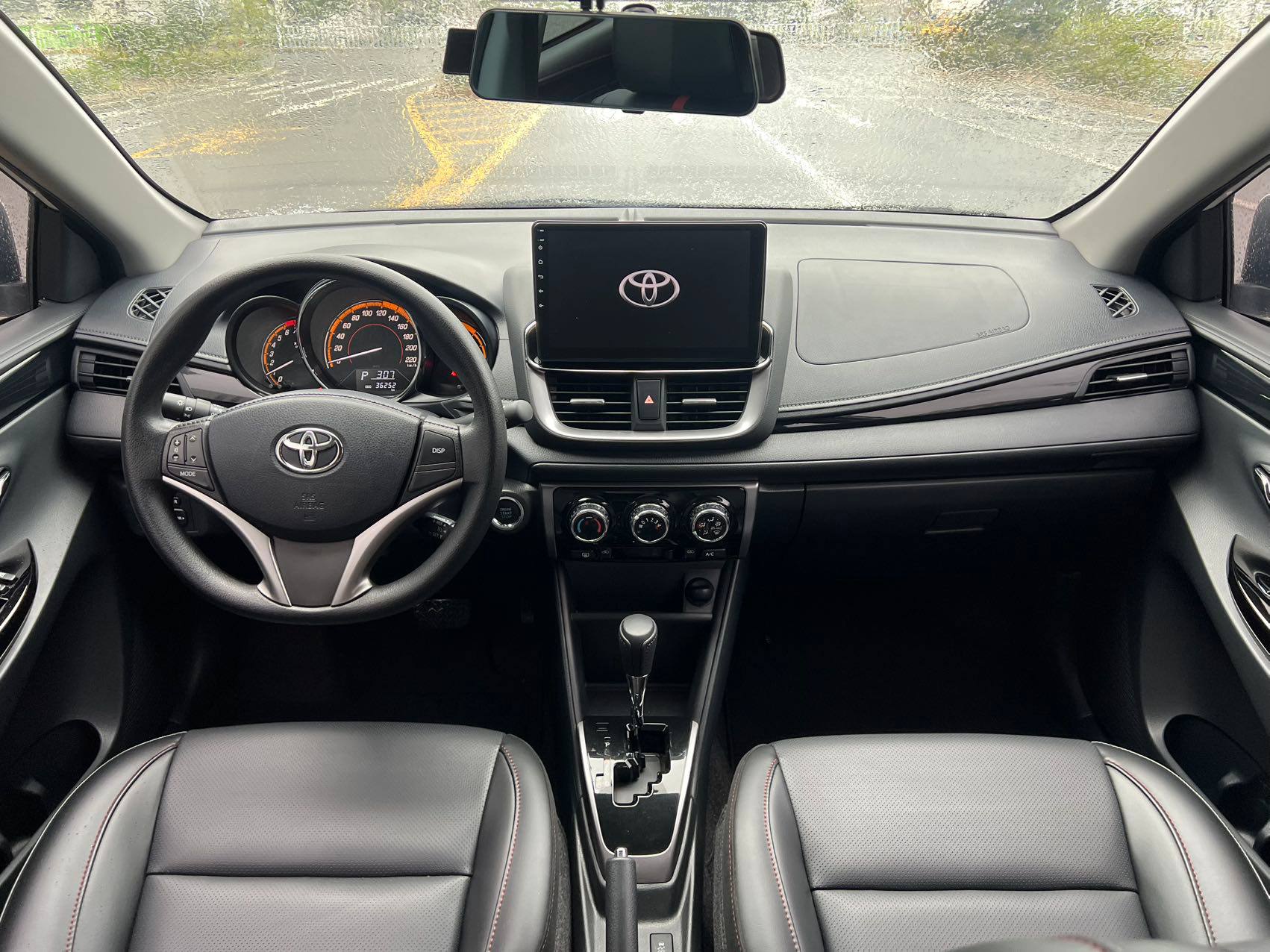 Передняя панель Toyota Yaris L: экран мультимедиа и три крутилки климата
